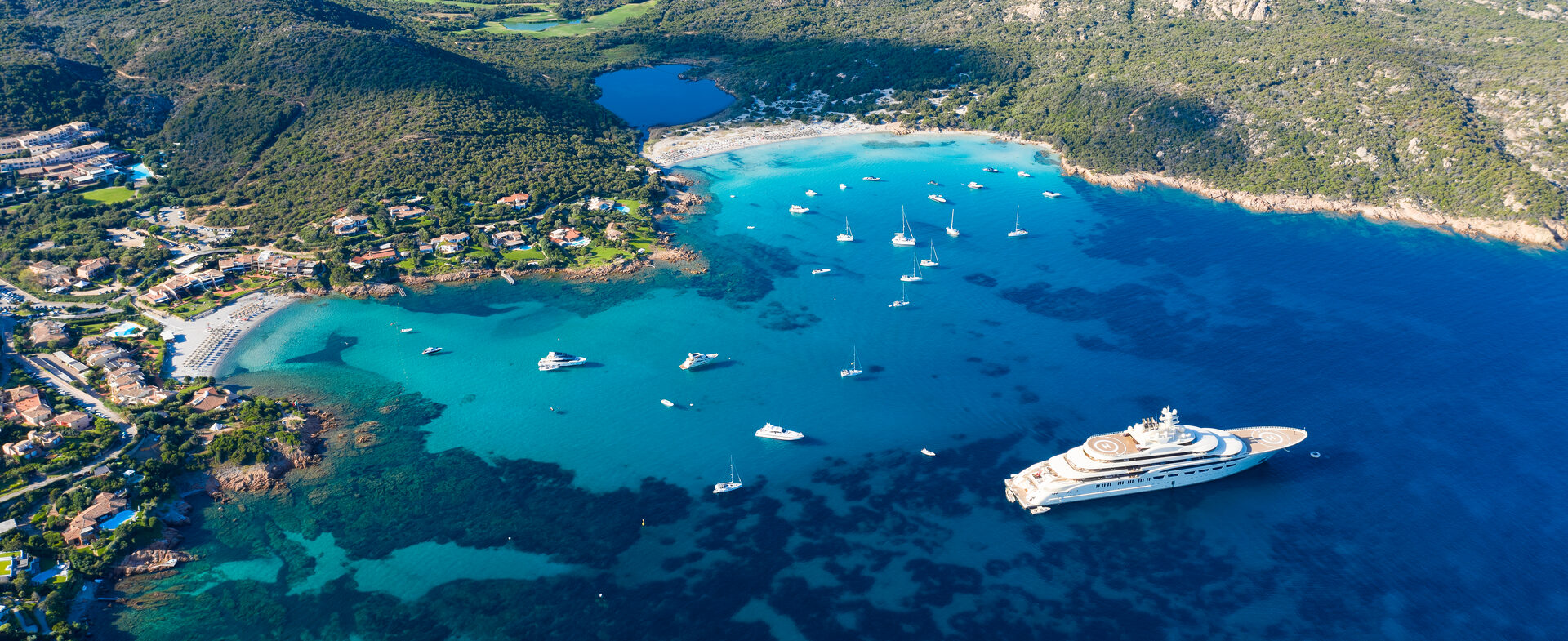 A superyacht anchored in a calm coastal bay