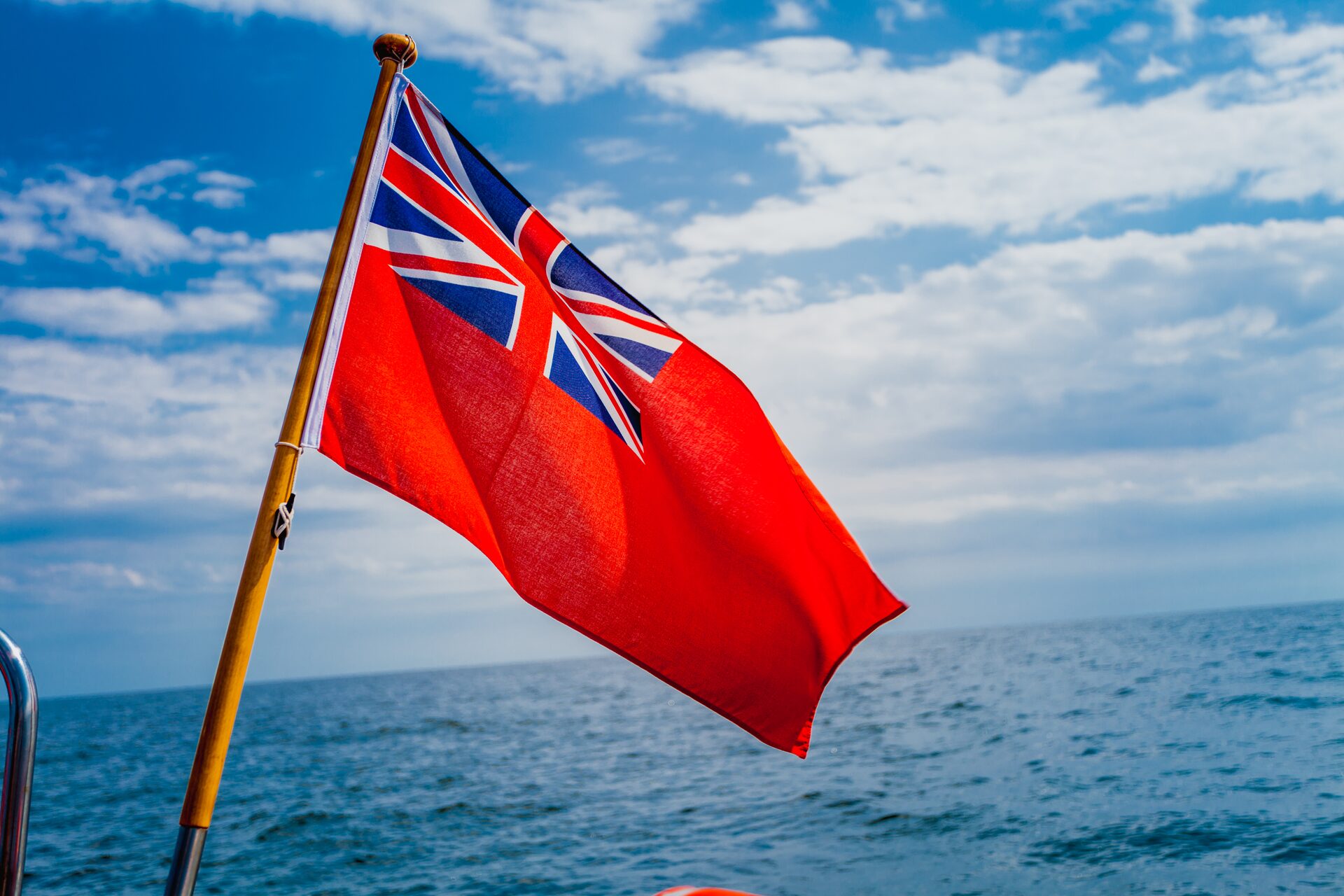 The British red ensign flying from a yacht against a clear sky